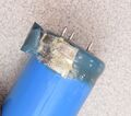 Sprague brand capacitor that has leaked and formed a powder moving up into the jacket of the capacitor.